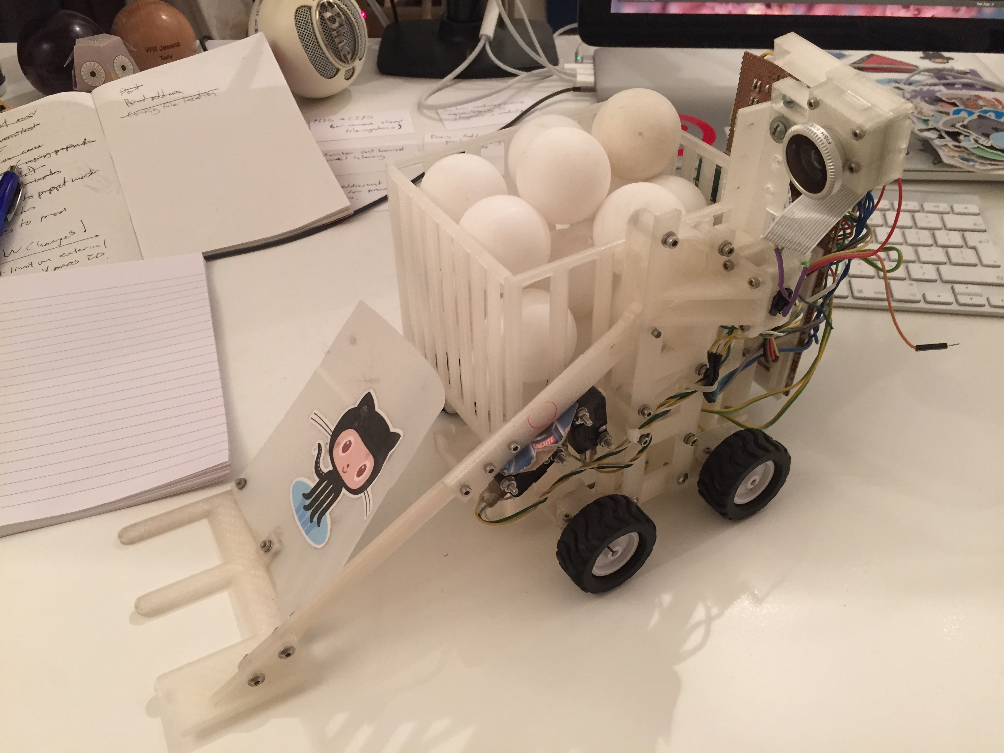 A robot view from the front left, a hopper full of ping pong balls on it's back