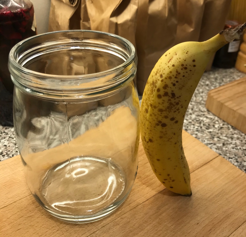 Sourdough container with a banana propped against it at a jaunty angle
